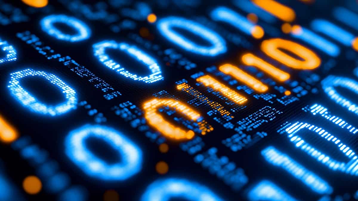 vista macro de números digitales luminosos en azul y naranja sobre fondo oscuro, mostrando dígitos pixelados como 0, 1 y otros caracteres numéricos con efecto de desenfoque, creando una representación visual abstracta de datos o código binario